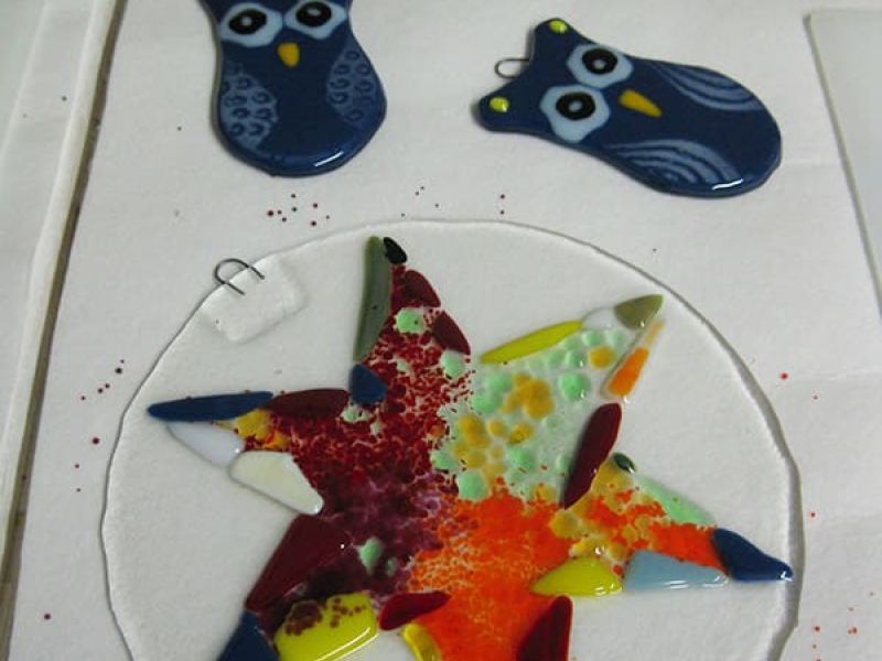 Glas-Kunstwerke schmelzen in Form von Sternen und Eulen