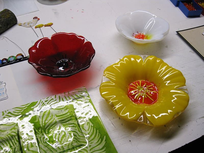 Glasschalen in Blumenformen in Rot, Gelb und Weiss entstanden im Fusingkurs in Pressbaum